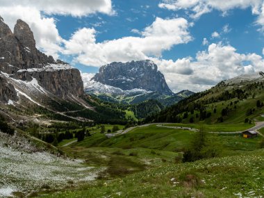 Navigate the serpentine road through Gardena Pass, leading you on a picturesque journey toward the majestic Piz Culac in the heart of the Dolomites clipart