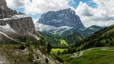 The winding road through Gardena Pass offers stunning views as it curves toward Piz Culac, showcasing the dramatic beauty of the Dolomites clipart