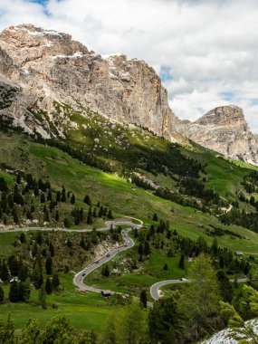 Embark on a journey along the serpentine road through Gardena Pass, where each twist and turn offers breathtaking views of the rugged Dolomite landscape clipart