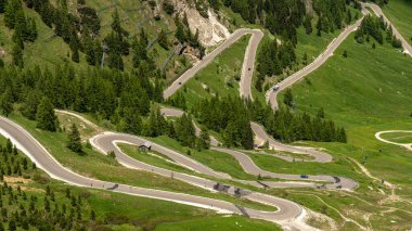 Serpentine Yolu 'nun büyüleyici kıvrımlarını tecrübe et Gardena Geçidi' nden dolan, her dönemeçte muhteşem Dolomitlerin muhteşem manzarasını sunan.