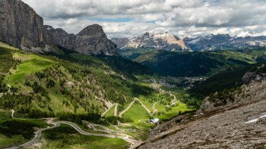 Sarmal bir yılan yolu Gardena Geçidi 'nden geçiyor, Colfosco' ya gidiyor, yüksek dağlar muhteşem bir zemin sağlıyor.