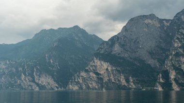 Lago di Garda 'nın dingin maviliği, arka plandaki engebeli sıradağlarla güzel bir tezat oluşturuyor. Doğal güzelliğin mükemmel bir karışımını sunuyor..