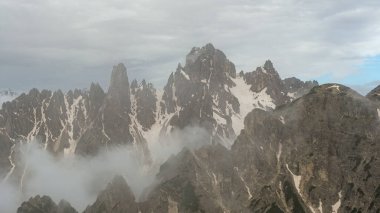 Dolomites' beauty in June: Snowy Tre Cime Circuit with unpredictable clouds adding to the alpine drama clipart