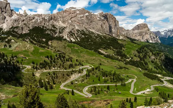 stock image Navigate the winding serpentine road through Gardena Pass, where each curve unveils the stunning Cir Group peaks towering in the background, showcasing the Dolomites' breathtaking beauty.