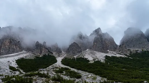 stock image Explore the hidden peaks of Val Vallunga as they rise from the mist, offering a breathtaking and surreal mountain experience shrouded in clouds.