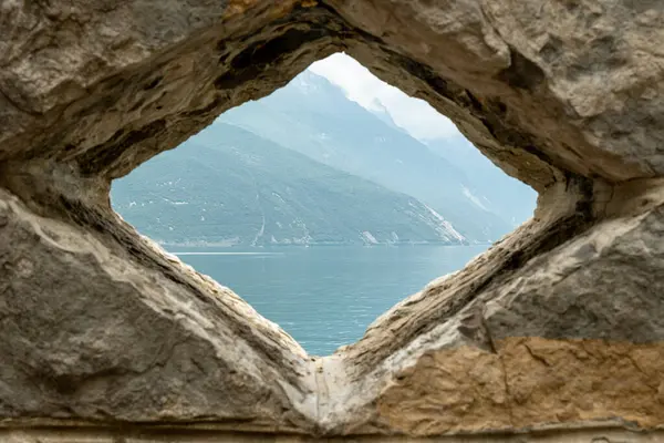 stock image The serene waters of Lago di Garda reflect the grandeur of the surrounding mountains, creating a picturesque harmony of lake and peak