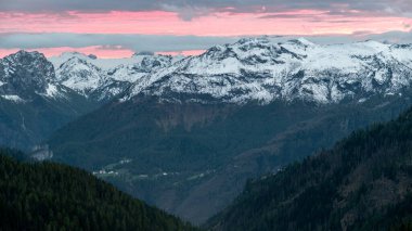 As the sun sets, the Dolomite mountains are bathed in the glow of vibrant red skies, creating a breathtaking contrast of fiery hues against the rugged alpine peaks. clipart