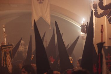 Tütsü dumanıyla dolu bir kilisenin içinde paskalya şapkaları takmış tövbe edenler..