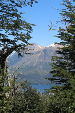 Arkasında dağlar olan gölün güzel manzarası.