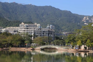 Bir köprü, bir şehrin önündeki bir su kütlesini kapsar. Köprü ağaçlar ve binalarla çevrili.