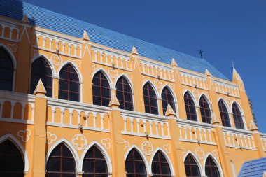 The building is yellow and blue with arched windows. The blue roof has a cross on it clipart