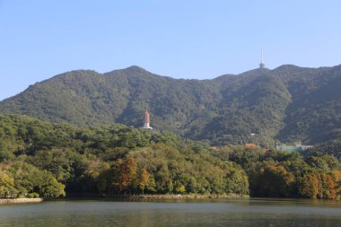 Ortasında büyük bir tepe ve sağında küçük bir tepe olan bir dağ sırası. Sağdaki tepe ağaçlarla kaplı ve tepesinde bir kule var.