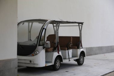 Siyah önü olan beyaz bir araç kaldırıma park edilmiş. Araç, siyah önü olan küçük, beyaz bir servis otobüsü.
