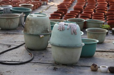 Bir yığın yeşil tencere ve bir çift eldiven. Eldivenler yeşil bir tencerenin üstünde.