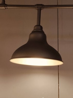 Beyaz gölgeli bir lamba aydınlatılıyor, odayı aydınlatıyor. Işık açık ve gölge açık. Işığın içeri girmesini ve sıcak, davetkar bir atmosfer yaratmasını sağlıyor.