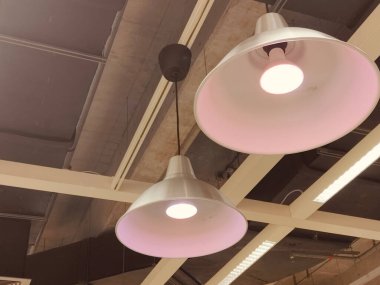 Tavandan sarkan iki lamba parçası, biri pembe. Diğeri de beyaz. Pembe armatür aydınlanırken beyaz armatür yanmıyor.
