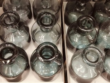 Temiz cam tabanlı ve siyah kapaklı vazolar. Vazolar sıralanmış ve hepsi aynı boyutta.