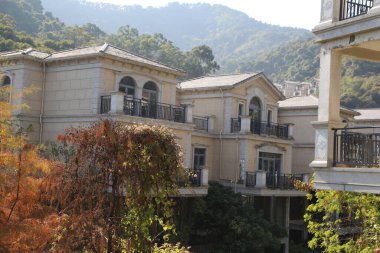 Üst katında balkon olan bir dizi ev. Evler uzun ve bir sürü pencereleri var. Balkondan dağların manzarası görünüyor.