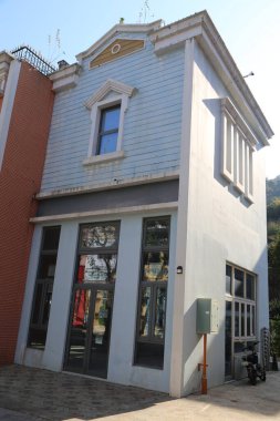 Kırmızı tuğlalı mavi bir bina. Binanın bir sürü penceresi ve balkonu var.