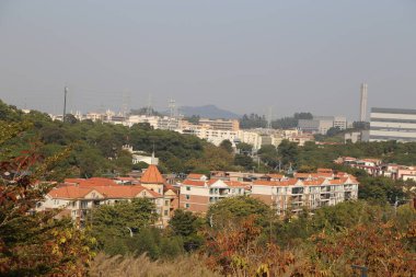 Bir binanın üzerinde kahverengi çatılı bir şehir manzarası. Binalar çok yüksek ve çok kalabalıklar.