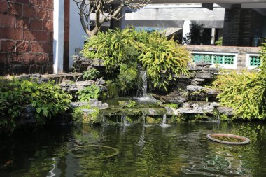 Küçük bir şelale bitki ve kayalarla dolu bir bahçededir. Su berrak ve sakin. Bahçe huzurlu ve rahatlatıcı.