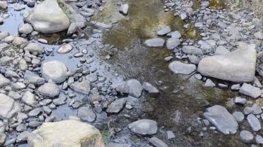 Her iki taraftaki taşlar ve çakıl taşlarıyla çevrili su yoluna çıkan taş basamaklar zamanla aşınarak yukarı bakan bir manzarayla onları parlak siyah hale getirdi. Nehir beton merdivenlerden geçerek başka bir alana akar. 