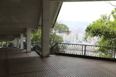 Yüksek bir balkondan bir şehir manzarası. Manzara yüksek binaları ve bir nehri olan bir şehir. Balkon boş ve tuğla zemini var.