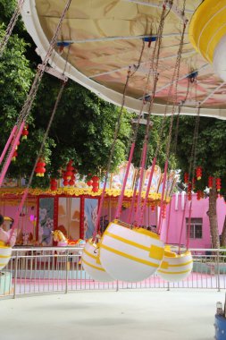 Pembe ve sarı renkli bir karnaval gezisi. Yolculuk tavandan askıya alınmış ve pembe ve sarı bir rengi var.