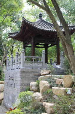 Taş kemerli taş bir duvar, küçük bir pavyona açılıyor. Çadırın etrafı kayalarla çevrili ve çatısı var. Huzurlu ve huzurlu bir sahne.