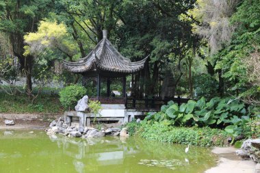 Parkta yeşil ağaçlar ve bitkilerle çevrili, yanında yapay bir göl bulunan Çin tarzı bir pavyon. Çardak ahşaptan yapılmıştır. Tabanın her iki tarafında da beyaz taş heykeller vardır..