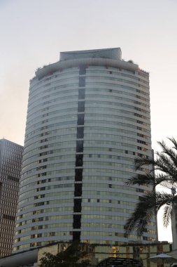 Bir sürü penceresi ve balkonu olan yüksek bir bina. Bina çok yüksek ve bir sürü penceresi var.