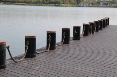 İskeleye bağlanmış ahşap direkler. Rıhtım bir su kütlesinin üzerinde.