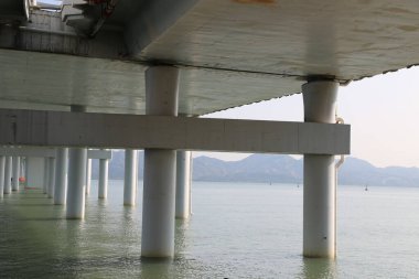 Deniz manzaralı bir köprü iskelesi. Su sakin ve köprü boş.