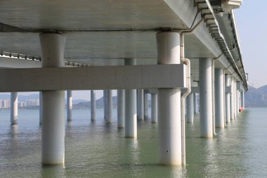 Suda uzun bir iskelesi olan bir köprü. Su sakin ve köprü boş.