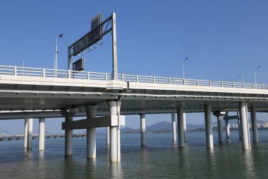 Üzerinde işaret olan bir su birikintisinin üzerindeki köprü. Köprü uzun ve su boyunca uzanıyor.