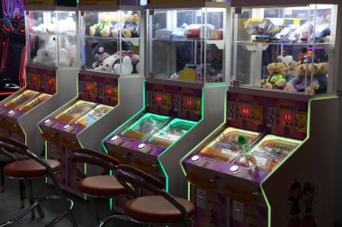 Makinenin önünde bir kız ve bir oğlanla atari masası oyunları. Oyunlar aydınlandı ve neon parlıyor.