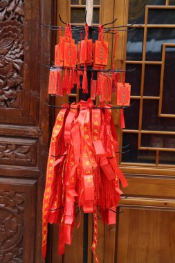 Çin 'deki antik bir binanın kapısında, ince kağıt şeritlerden örülmüş ve altın kenarlarla süslenmiş kırmızı bir kurdele asılıdır..