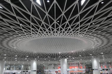 Havaalanının devasa tavanı, dairesel çatı yapısına benzeyen zarif ve simetrik bir desen oluşturan üçgen metal fayanslarla kaplıdır..