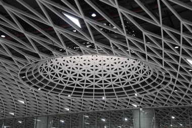 Metal ağ ve çelik kirişli çatı tasarımı, sekizgen şeklinde, Shenzhen Yüksek Hızlı Tren İstasyonu 'nda. Tavan, simetrik tarzda geometrik desenler yaratan beyaz çizgilerden oluşur..