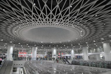 Shenzhen 'deki yüksek hızlı tren istasyonunun tavanında karmaşık geometrik desenler oluşturan bir dizi beyaz metal örgü modern ve geleceksel bir ambiyans oluşturur. Yapı gümüş çelik elementlerle süslenip, zarafetine katılıyor.