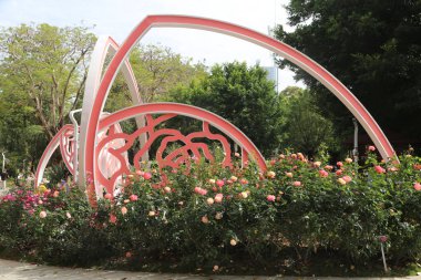 Şehir parkında, üzerinde pembe ve kırmızı güller büyüyen soyut bir gül kemeri var. Heykelde, gür yeşilliklerle çevrili kalp veya kalp şeklindeki taç yapraklarına benzeyen modern tarz metal heykeller yer alıyor..