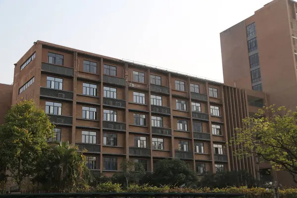 Çin Üniversitesi 'nde üç katlı bir öğrenci yurdu. Koyu kahverengi tuğlaları ve gri metal pencereleri olan modern mimarinin dış görünüşü. Ön cephede her katta demir bir balkon korkuluğu var.