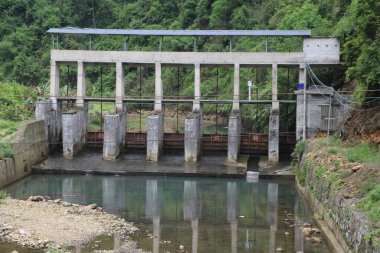 Güney Çin 'in dağlık kesimlerinde üç su tutma duvarı ve her duvarda dört sızıntı yolu olan izole edilmiş bir baraj var. Önündeki yüzme alanı beton levhalarla çevrili..