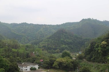 Vadide küçük bir köyü olan bir dağ sırası. Köy ağaçlar ve evlerle çevrili.