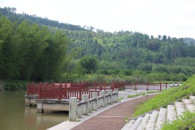 Nehir boyunca yeşil bitki örtüsü ve şehrin her iki yakasındaki uzun ağaçlarla çevrili kırmızı bir korkuluk. Tahta korkuluklar betondan yapılmıştır. Bazı beyaz adımlar insanların rahatlaması için açık bir alana çıkar.