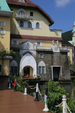 Otelin dış kısmında sarı duvarlar, beyaz süsleme ve kırmızı çatı kiremitleri gibi yeşil bitkilerle süslenmiş antik bir taş kemer girişi bulunan elementler bulunur. Bina ahşap bariyerlerle çevrili, çeşitli reklamlara çıkıyor.