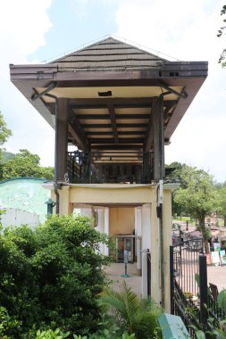 Evcil hayvan çiftliğinin girişinde yükseltilmiş balkonlu küçük bir açık hava binası. Çiçek pazarı ve yeşil bir alanın önünde, ahşap bir yapı tarzında inşa edilmiş..