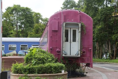 Pembe ve beyaz bir tren vagonu, bir tarafında kapı açık. Dış tarafı metalden yapılmıştır. İçerisi ise oturma ya da dinlenme yeri olarak kullanılabilir..