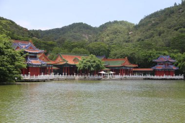 Sahilde binaları olan büyük bir su kütlesi. Binalar kırmızı ve beyaz.