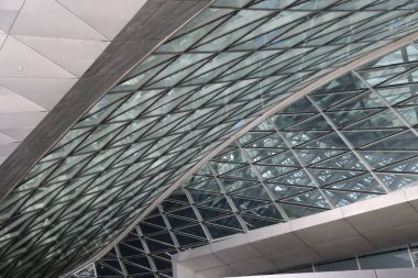 the roof of the exhibition hall is made up of glass triangular structures, forming an open space with sharp edges and a sense of modernity. the metal structure underneath adds strength to it.